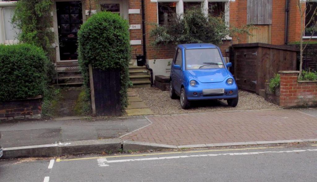 Yellow line protecting cross-over invades neighbours' frontage & eats up usable parking space.